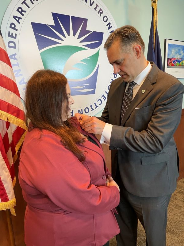 Photo of WLC student Chrissy Parise with DEP Secy. Richard Negrin presenting her with a special pin